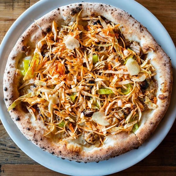 MOROSO Italian Ristorante's pizza, topped with shredded cabbage, green peppers, and garlic slices.