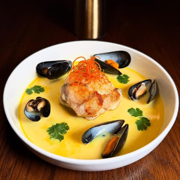 MOROSO's Italian seafood dish with fish, mussels, and cilantro in a yellow broth.