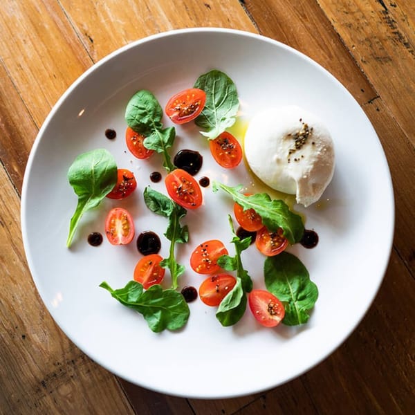 MOROSO Italian Ristorante's burrata with cherry tomatoes, arugula, olive oil, and balsamic glaze.